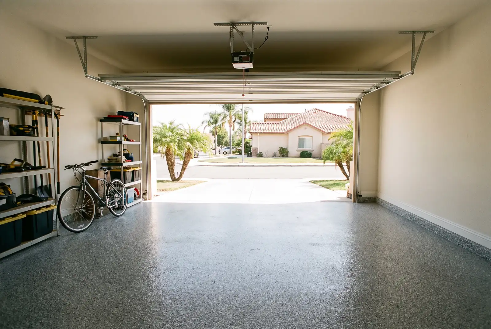 Gray flake epoxy floor in a two-car garage with the door open