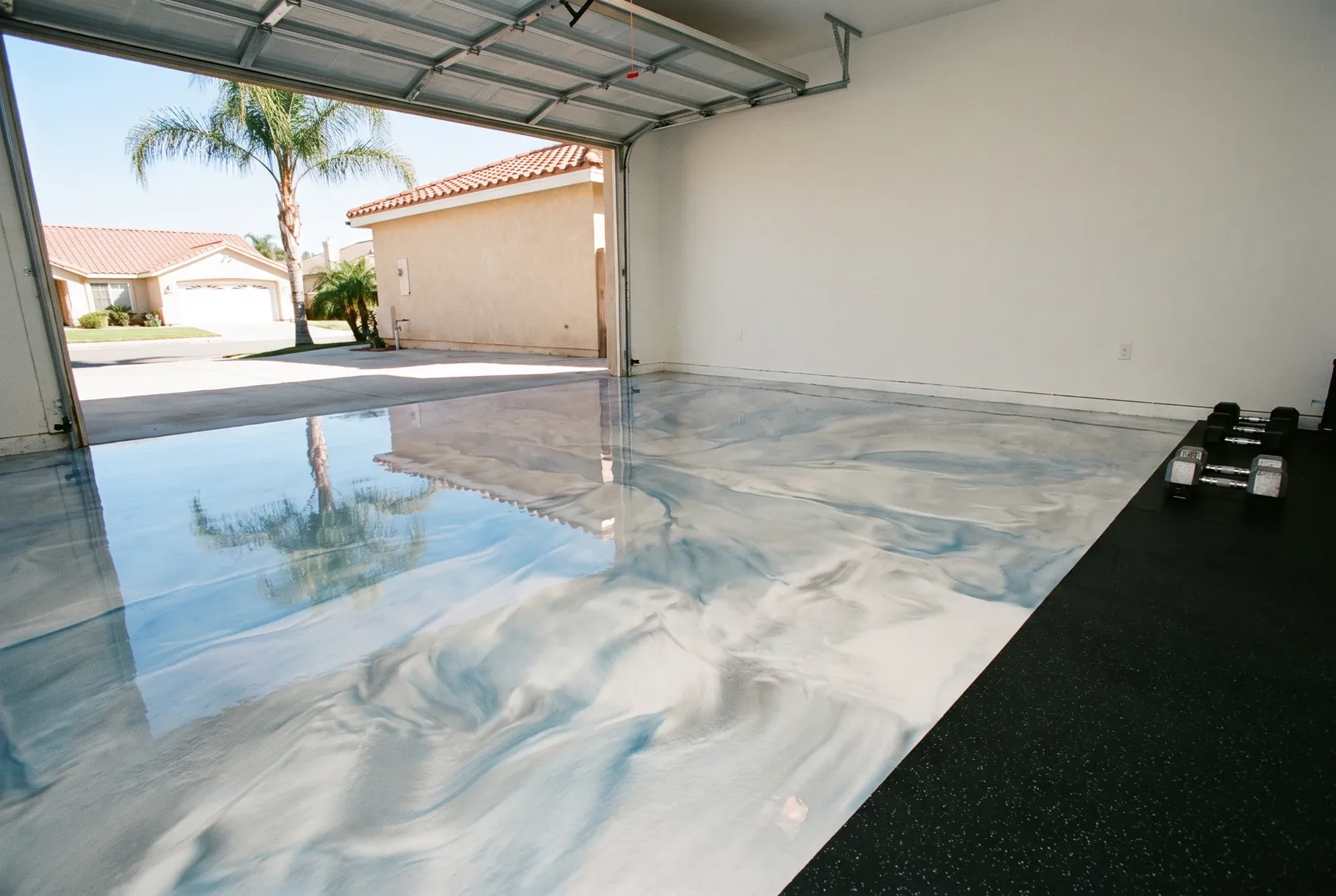 Pearl and blue metallic epoxy floor in a garage home gym